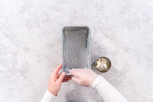 Flat lay. Greasing loaf pan with vegetable shortening to bake sweet pumpkin bread.
