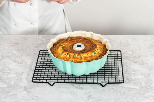 Cooling freshly baked funfettti bundt cake on a wire rack.