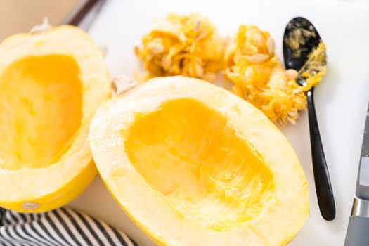 Preparing organic spaghetti squash with olive oil, salt, and pepper.