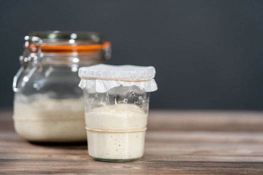 Feeding sourdough starter in a glass mason jar for baking artisan bread.