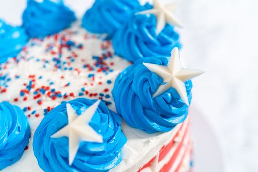 Decorating chocolate cake with white, red, and blue buttercream frosting for July 4th celebration.