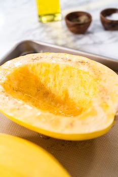 Preparing organic spaghetti squash with olive oil, salt, and pepper.