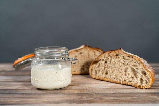 Feeding sourdough starter in a glass mason jar for baking artisan bread.