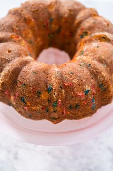 Close up view. Funfettti bundt cake prepared for frosting on a cake stand.