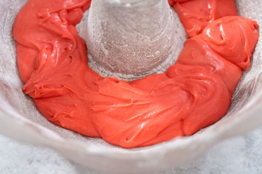 Filling bundt cake pan with red, white, and blue cake dought to bake July 4th bundt cake with chocolate stars.