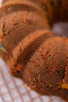 Close up view. Cooling freshly baked funfettti bundt cake on a wire rack.