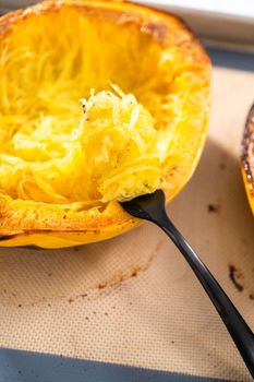 Preparing organic spaghetti squash with olive oil, salt, and pepper.