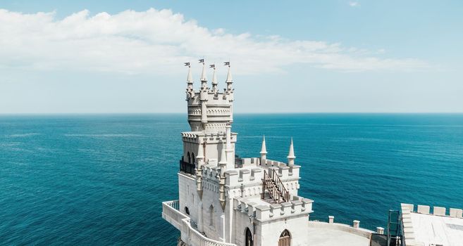 Aerial view of Swallow's Nest castle on the rock in Black Sea. It is a symbol and landmark of Crimea. Beautiful scenic panorama of the Crimea coast. Amazing Swallow's Nest at the precipice.