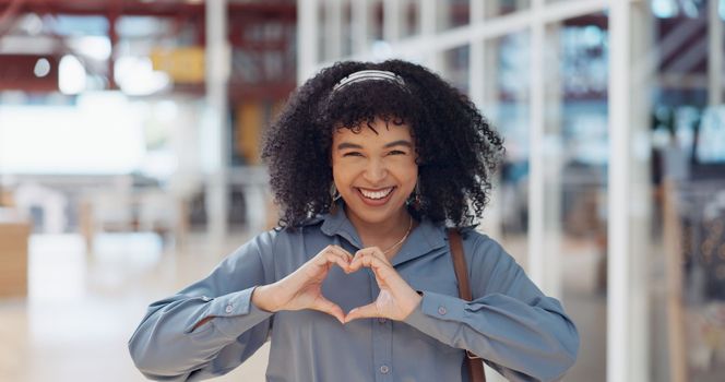 Hands, heart and love with a business black woman making a hand gesture alone in her office at work. Happy, smile and positive with a female employee gesturing a hand sign for romance or affection.