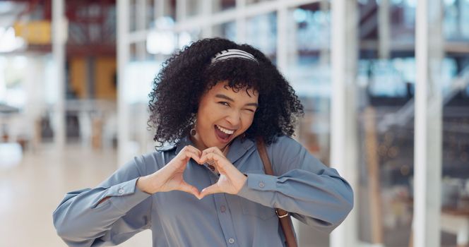 Hands, heart and love with a business black woman making a hand gesture alone in her office at work. Happy, smile and positive with a female employee gesturing a hand sign for romance or affection.