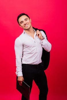 Image of young cheerful businessman holding and using laptop isolated over red background