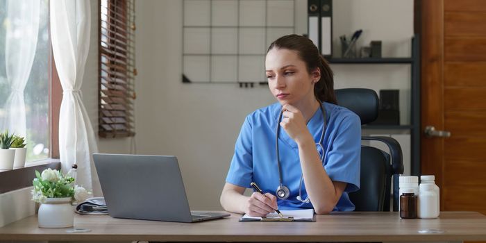 Portrait of female asian doctor working in her office at clinic.