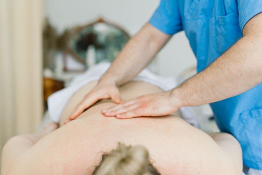 Young fat woman getting massage treatment in a day spa cabinet.