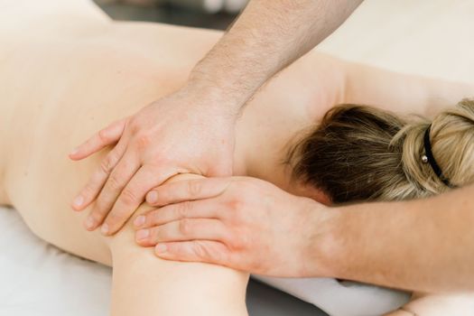 Young fat woman getting massage treatment in a day spa cabinet.