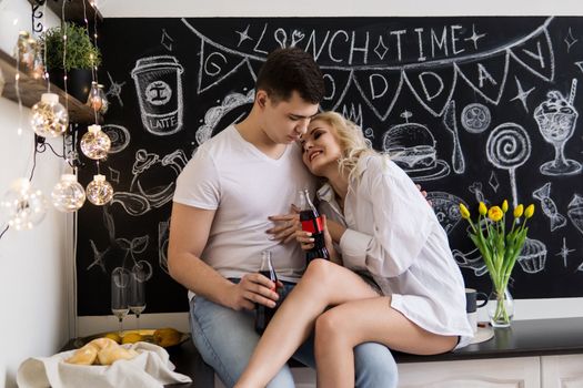 Love is quarantined during the Coronavirus. This is the new normal. A young couple in love in their home kitchen