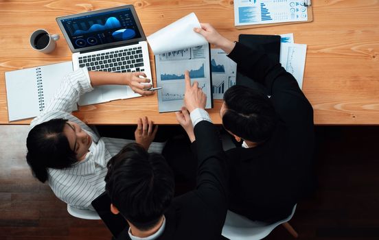 Top-view business team of financial data analysis meeting with business intelligence, report paper and dashboard on laptop for marketing strategy. Business people working together in office of harmony