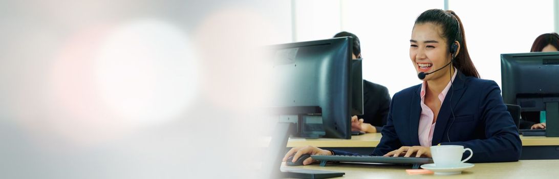 Business people wearing headset working in office in widen view to support remote customer or colleague. Call center, telemarketing, customer support agent provide service on telephone video call.