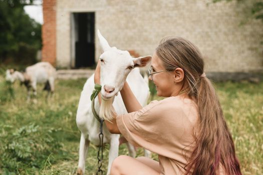 Girl hugging her goat as a friend in the village