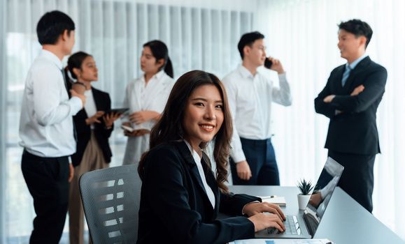 Focus portrait of female manger, businesswoman in the harmony meeting room with blurred of colleagues working together, analyzing financial paper report and dashboard data in background.