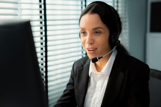 Competent female operator working on computer and talking with clients. Concept relevant to both call centers and customer service offices.