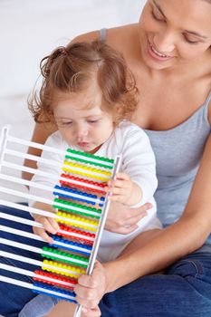 Learning at home. A baby girl and her mother playing with an abacus