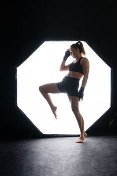 Young woman athletic female MMA fighter is training. Concept of sport, action, healthy lifestyle.