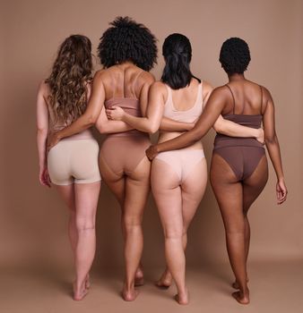 Back, diversity and body positivity with woman friends in studio on a brown background for natural confidence. Normal, behind and inclusion with a female friend group posing to promote real people.