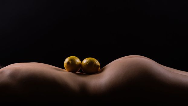 Lemon, natural vitamin c help skin whitening. Naked woman lying on back with fruit located