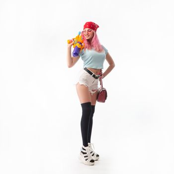 sexy girl with a water gun in summer clothes isolated on a white background copy paste