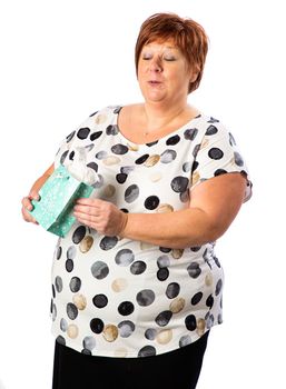 Isolated portrait of a fifty year old overweight red hair woman trying to figure out what's in a gift bag
