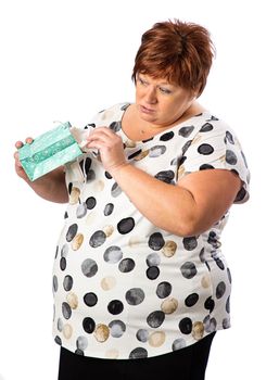 Isolated portrait of a fifty year old overweight red hair woman trying to peak into a gift bag

