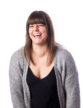 Isolated portrait of a forty year old woman, wearing a gray vest, laughing her hear out