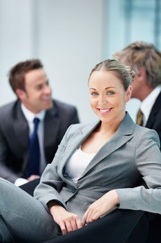 Relaxed business woman with other executives. Portrait of relaxed business woman smiling with other executives in background