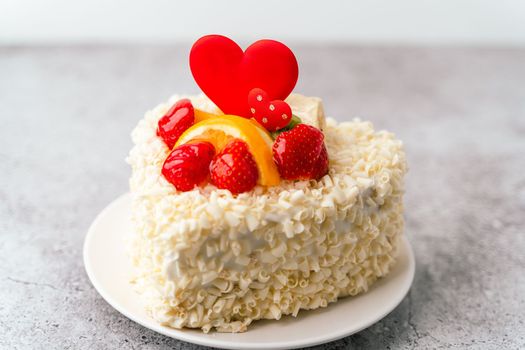 Valentine's Day cake with heart shape and fruits, strawberries. Birthday Cake for celebration. Valentine's Day and love concept. Present with love.