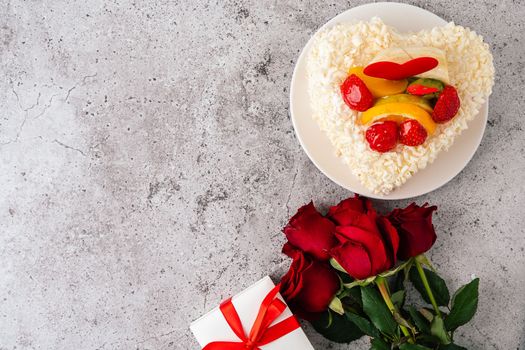 Valentine's Day cake, roses flowers with heart shape and fruits, gift, flat lay. top view. Birthday Cake for celebration with copy space. Valentine's Day and love concept. Present with love.