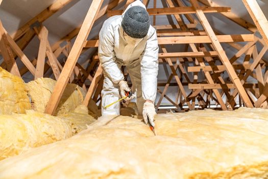 cutting glass wool when insulating the ceiling on the roof.