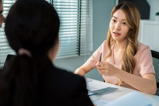 A young female asian candidate tries to impress her interviewer by being competent. International company, multicultural environment in workplace.