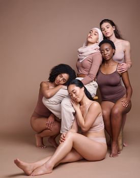 Diversity, woman and body positive skincare beauty for inclusion, spa dermatology wellness and natural body care in studio. Interracial model friends, support and relax cosmetic equality in underwear.