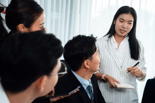 Harmony in office concept as business people analyzing dashboard paper together in workplace. Young colleagues give ideas at manager desk for discussion or strategy planning about project.