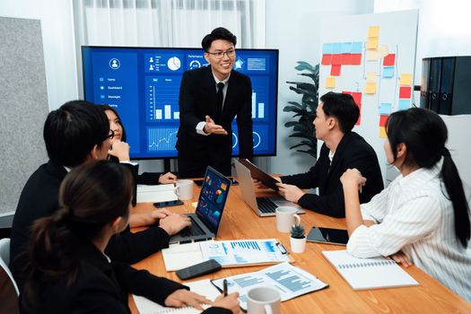 Confidence and asian businessman give presentation on financial analyzed by business intelligence in dashboard report to other people in board room meeting to promote harmony in workplace.