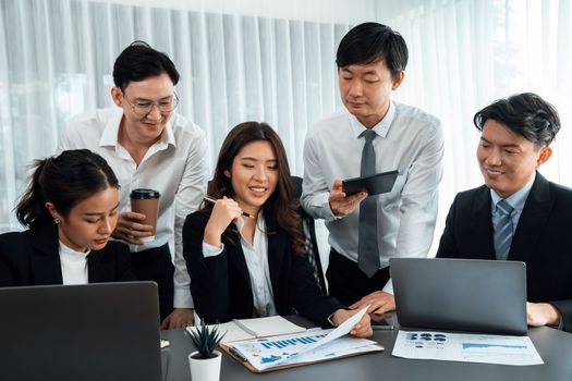 Harmony in office concept as business people analyzing dashboard paper together in workplace. Young colleagues give ideas at manager desk for discussion or strategy planning about project.