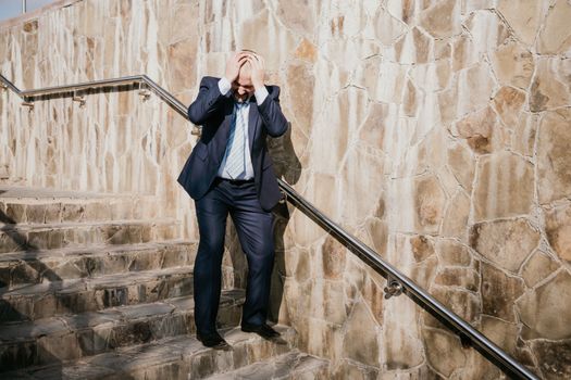 Portrait of a senior professional man in a suit with various problems. A middle-aged businessman with a briefcase descends the stairs.