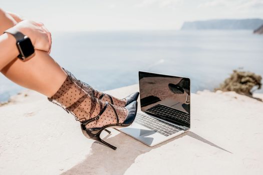 Happy girl doing yoga with laptop working at the beach. beautiful and calm business woman sitting with a laptop in a summer cafe in the lotus position meditating and relaxing. freelance girl remote work beach paradise