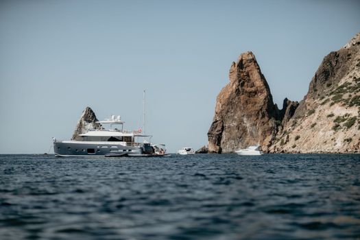 Aerial boat race. Luxury cruise trip. View from above of white boat on deep blue water. Aerial view of rich yacht sailing sea. Motor boat racing wave. Summer journey on luxury ship