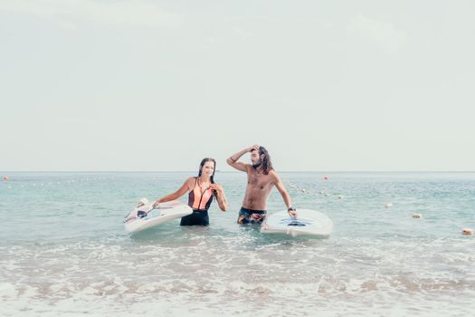 Woman man sea sup. Close up portrait of beautiful young caucasian woman with black hair and freckles looking at camera and smiling. Cute woman portrait in a pink bikini posing on sup board in the sea