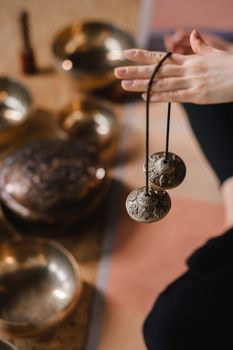 Close-up of a woman's hand holding Tibetan bells for sound therapy. Tibetan cymbals.