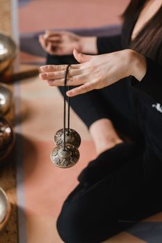 Close-up of a woman's hand holding Tibetan bells for sound therapy. Tibetan cymbals.