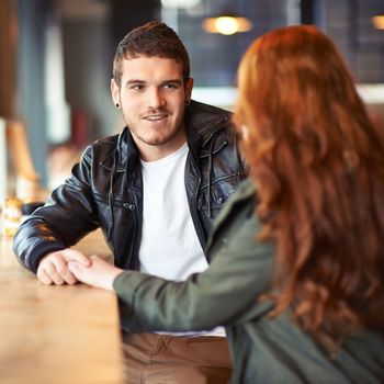 Hes got loads of charm. A cropped shot of a young affectionate couple on a coffee date