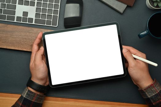 Above man hands holding digital tablet with blank screen over black leather at workspace. Empty screen for your advertise design.