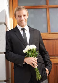 Love, portrait and man with flowers for valentines day, romance or gesture while standing against a wall background. Roses, happy and gentleman with bouquet for sweet, anniversary gift or first date.